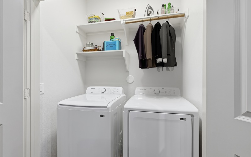 full size washer and dryer in laundry room with racks and shelves